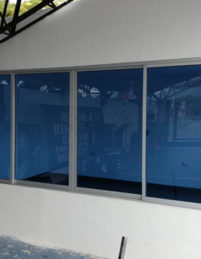 Ventana corrediza sistema 744 aluminio natural y vidrio azul