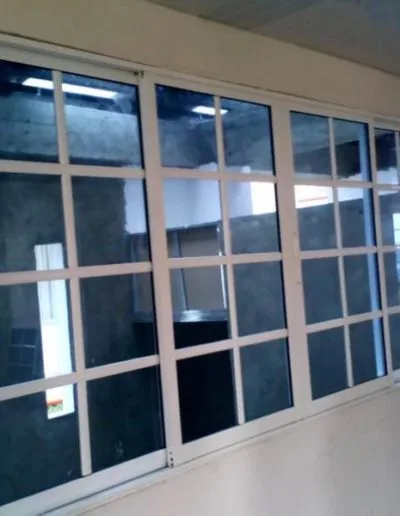 Ventana corrediza sistema 744 con vidrio azul reticulado